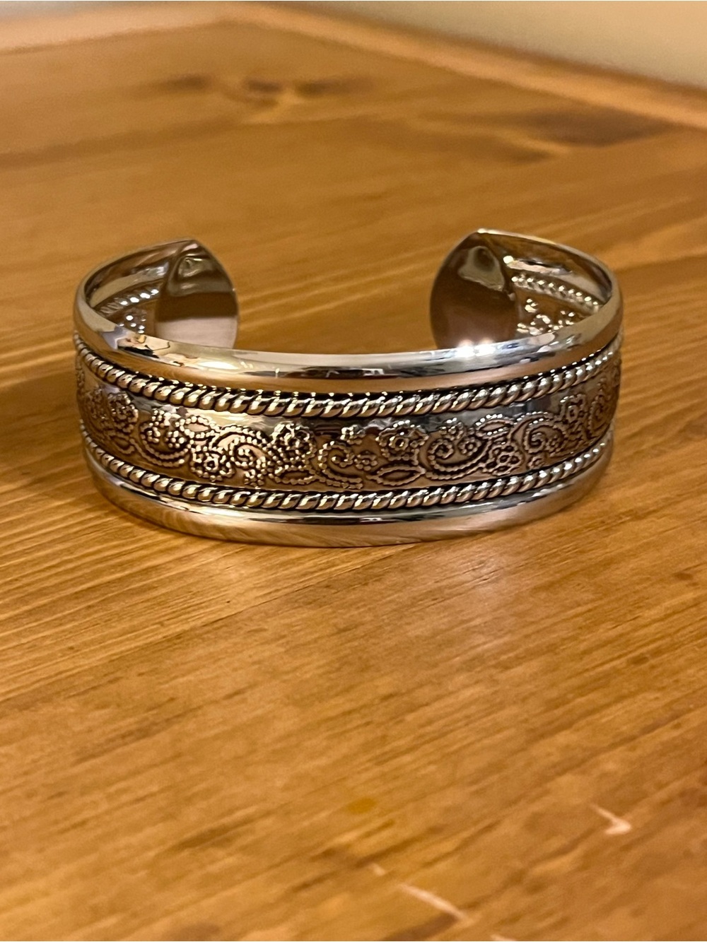 Shiny silver tone cuff with flower vine design etched with dots 7 1/2”